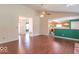 Spacious living room with wood floors, a ceiling fan, and access to the kitchen and hall at 626 Tulip Poplar Ct, Mooresville, IN 46158