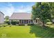 Lush backyard featuring a manicured lawn, mature trees, and screened-in porch at 6528 Fountain Springs Blvd, Indianapolis, IN 46236