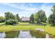 Expansive backyard featuring a pond, mature trees, and a well-maintained lawn at 6528 Fountain Springs Blvd, Indianapolis, IN 46236