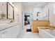 Bright bathroom featuring dual sinks, a soaking tub, a glass-enclosed shower, and stylish finishes at 6528 Fountain Springs Blvd, Indianapolis, IN 46236