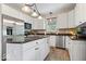 Well-lit kitchen with stainless steel appliances, white cabinets, dark countertops, and a functional island at 6528 Fountain Springs Blvd, Indianapolis, IN 46236