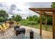 Outdoor deck with grilling area, seating, and view of landscaped backyard at 6532 Amherst Way, Zionsville, IN 46077