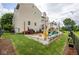 Landscaped backyard featuring a stone patio, firepit, and outdoor seating at 6532 Amherst Way, Zionsville, IN 46077