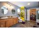 Well-lit bathroom with dual sinks, framed mirrors, a toilet, and open access to a closet at 6532 Amherst Way, Zionsville, IN 46077