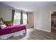 Bright bedroom with two windows, neutral walls, grey curtains and wood floor at 6532 Amherst Way, Zionsville, IN 46077