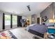 Spacious bedroom featuring gray walls, light wood floors, a ceiling fan, and adjacent bathroom at 6532 Amherst Way, Zionsville, IN 46077