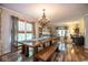 Bright dining room with a large glass table and bench seating beneath a gorgeous chandelier at 6532 Amherst Way, Zionsville, IN 46077