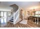 Inviting foyer featuring a staircase and beautiful wood flooring that opens into the dining room at 6532 Amherst Way, Zionsville, IN 46077