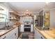 Well-lit kitchen featuring butcher block countertops, stainless steel appliances, and open shelving at 6532 Amherst Way, Zionsville, IN 46077