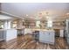 Kitchen with island, stainless steel appliances, modern lighting, open shelving, hardwood floors, and an open layout at 6532 Amherst Way, Zionsville, IN 46077