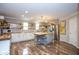 Bright kitchen featuring an island, stainless steel appliances, open shelving, and hardwood floors at 6532 Amherst Way, Zionsville, IN 46077