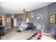 Spacious main bedroom featuring unique wall decor, ceiling fan, and wood-look flooring at 6532 Amherst Way, Zionsville, IN 46077
