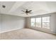 Large bedroom featuring tray ceilings, natural light from the windows, and neutral carpeting at 6670 Shooting Star Dr, Whitestown, IN 46075