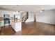 Spacious open-concept area featuring hardwood floors, abundant natural light, staircase, and a stylish kitchen at 6670 Shooting Star Dr, Whitestown, IN 46075