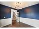 Comfortable study with hardwood floors, modern light fixture, wainscotting, and an open door frame at 6670 Shooting Star Dr, Whitestown, IN 46075