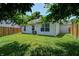 Well-manicured backyard featuring green lawn, vinyl siding, mature trees, and privacy fence at 6740 Sundown S Dr, Indianapolis, IN 46254