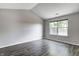 A bedroom with gray walls, wood-look floors, and a window providing natural light at 6740 Sundown S Dr, Indianapolis, IN 46254