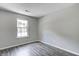 A bedroom with gray walls, wood-look floors, and a window providing natural light at 6740 Sundown S Dr, Indianapolis, IN 46254