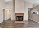 Open floor plan with fireplace, wood flooring, and view into kitchen at 6740 Sundown S Dr, Indianapolis, IN 46254