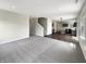 Spacious living room with plush carpeting, open layout, and view of modern kitchen at 6933 Sonora Blvd, Clermont, IN 46234