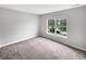 Empty bedroom with plush carpet, neutral wall paint, and a view out the window at 770 Tulip Ln, Greenwood, IN 46143
