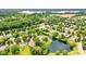 Community aerial view with mature trees, a pond, and homes nestled in a lush green setting at 7755 Dayflower Ct, Noblesville, IN 46062
