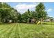 Spacious backyard with lush lawn and a wooden playset, perfect for outdoor fun at 7755 Dayflower Ct, Noblesville, IN 46062