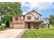 Attractive two-story home with a brick and siding facade, red shutters, a covered porch, and a well-kept lawn at 7755 Dayflower Ct, Noblesville, IN 46062