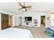 Bright main bedroom featuring a vaulted ceiling, ceiling fan, barn door, and a flat screen television at 7755 Dayflower Ct, Noblesville, IN 46062
