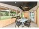 Enclosed patio featuring black metal furniture, wood paneled walls and a backyard view at 7755 Dayflower Ct, Noblesville, IN 46062