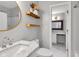 This bathroom is styled with floating shelves, a gold-rimmed mirror, and white fixtures at 8140 Bold Forbes Ct, Indianapolis, IN 46217