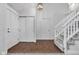 Bright entryway with dark wood floors, a front door, closet, stairway and modern light fixture at 8140 Bold Forbes Ct, Indianapolis, IN 46217