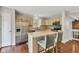 Well-lit kitchen with stainless steel appliances, an island with seating, and hardwood flooring at 8140 Bold Forbes Ct, Indianapolis, IN 46217