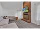 Bright living room featuring gray carpet, modern sofa, brick fireplace and tall window with white curtains at 8140 Bold Forbes Ct, Indianapolis, IN 46217