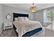 This main bedroom features a blue bedframe, decorative pillows, and an elegant chandelier for a cozy ambiance at 8140 Bold Forbes Ct, Indianapolis, IN 46217