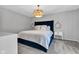 The main bedroom has a bright chandelier, wall decor, plush bed, and bedside table at 8140 Bold Forbes Ct, Indianapolis, IN 46217