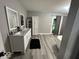 Bright bathroom featuring double sink vanity, tile floors and a decorative cabinet for ample storage at 8407 Campbell Ct, Mooresville, IN 46158