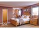 Comfortable bedroom with a wooden frame bed, carpet floors and soft lighting at 8905 Maze Rd, Indianapolis, IN 46259