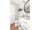 Bright bathroom featuring a granite vanity, oval mirror, and wood-look flooring at 8925 Sunburst Cir, Indianapolis, IN 46227