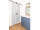 Charming bathroom with barn door, blue vanity, and marble countertop at 8925 Sunburst Cir, Indianapolis, IN 46227