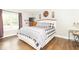 Inviting bedroom features a plaid comforter, wood floors, and natural light at 8925 Sunburst Cir, Indianapolis, IN 46227