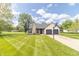 A cozy home featuring an attached two-car garage, a beautifully landscaped yard and stone chimney at 8925 Sunburst Cir, Indianapolis, IN 46227