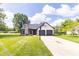 Charming home featuring an attached two-car garage, well-manicured lawn and basketball hoop on the driveway at 8925 Sunburst Cir, Indianapolis, IN 46227