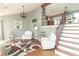 Inviting living room with vaulted ceilings, hardwood floors, staircase and comfortable white furniture at 8925 Sunburst Cir, Indianapolis, IN 46227