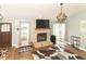 Cozy living room with stone fireplace, modern lighting, large rug, and comfortable seating at 8925 Sunburst Cir, Indianapolis, IN 46227
