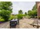 Lovely outdoor patio with stone pavers, fire pit, dining table, and mature landscaping at 9237 Rocky Cay Ct, Zionsville, IN 46077