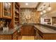 Custom wet bar features wood cabinetry, granite counters, brick accent wall and open shelving at 9237 Rocky Cay Ct, Zionsville, IN 46077