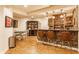 Basement wet bar with brick accents, pendant lighting, a seating area and dart board at 9237 Rocky Cay Ct, Zionsville, IN 46077