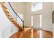 Grand foyer with hardwood floors, a curved staircase, and large windows that flood the space with natural light at 9237 Rocky Cay Ct, Zionsville, IN 46077
