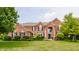 Beautiful red brick two-story home with mature trees, manicured lawn, black shutters, and an arched front entry at 9237 Rocky Cay Ct, Zionsville, IN 46077